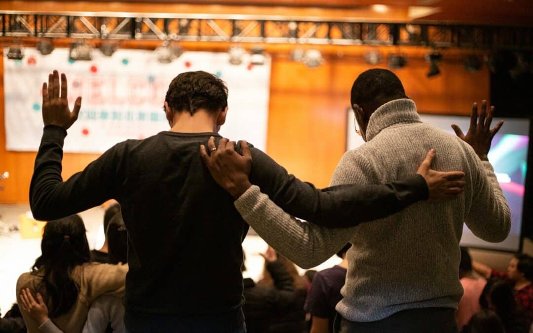 two men holding ear others hand